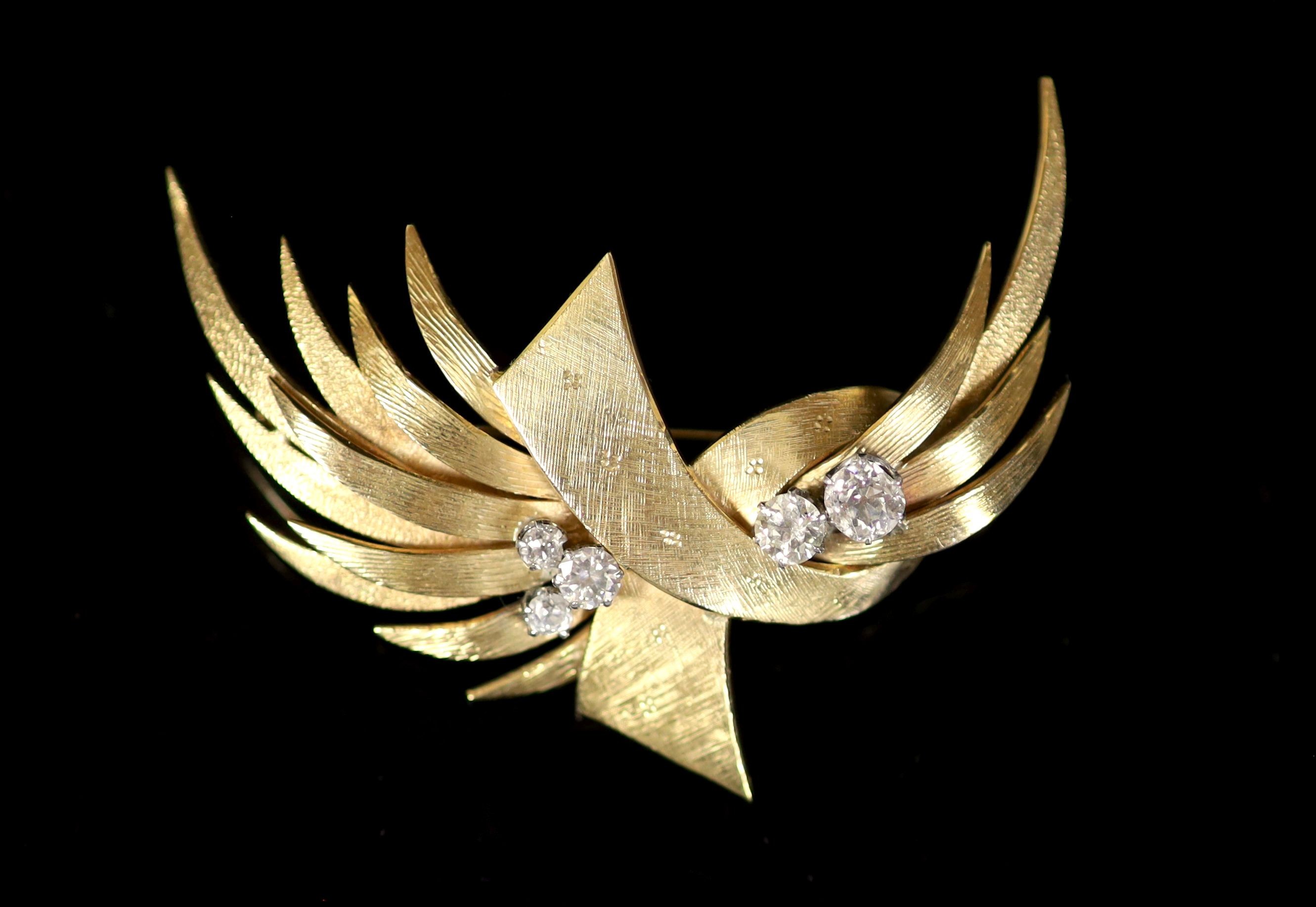 A continental textured gold and graduated five stone diamond set stylised spay brooch